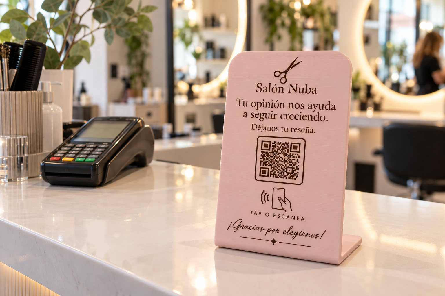 Placa NFC de reseñas rosa empolvado en la recepción de una peluquería, junto al datáfono